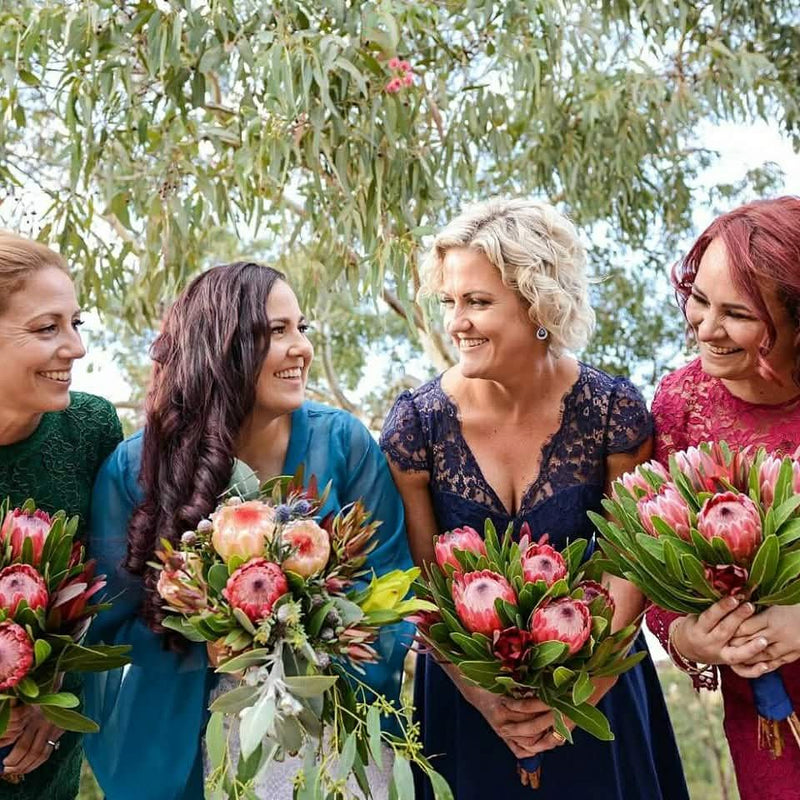 Bridal party with styled hair holding native protea bouquets