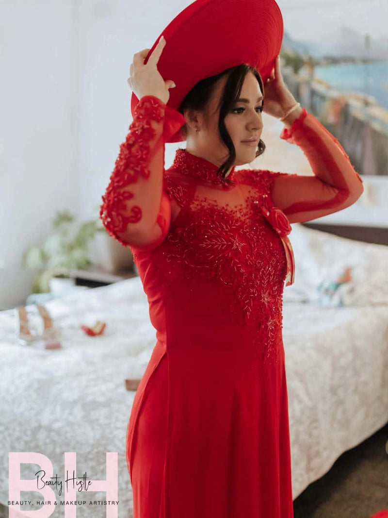 Bride in red lace gown with styled hair and makeup