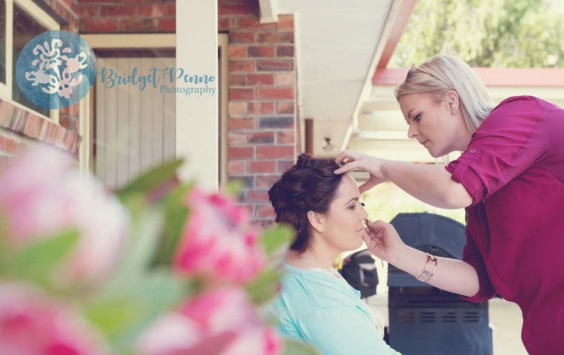 Simone applying makeup to a client on a wedding morning