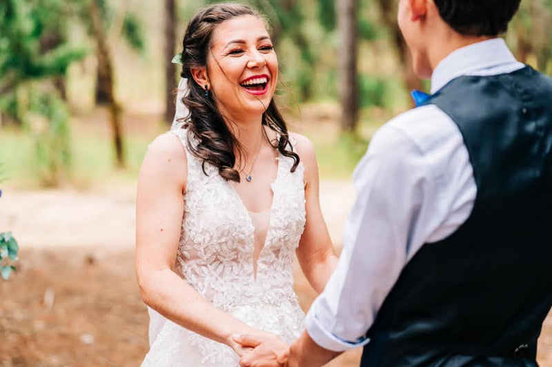 Laughing bride with long waves at the ceremony